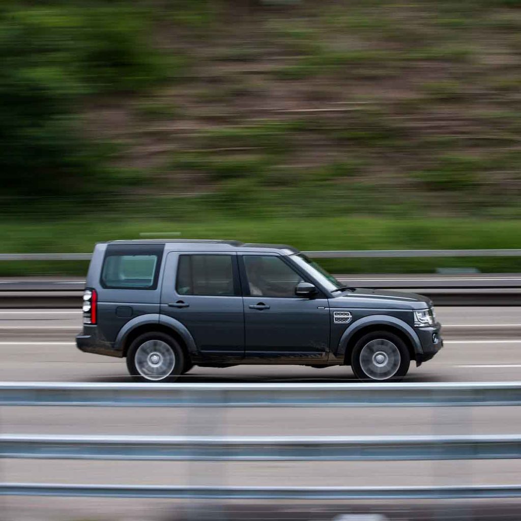 Luxury SUV driving on highway with blurred wheels