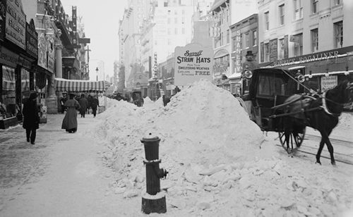 Vintage black and white photo of city with large piles of snow